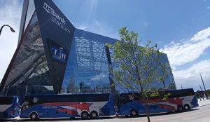 Lorenz Bus Service coaches parked outside US Bank Stadium in Minneapolis on a sunny day