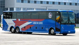 Lorenz Bus Service full-size motorcoach with blue exterior and star logo parked outside a facility