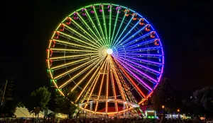 and were not provided, so I'll treat this as an informative image. Colorful illuminated Ferris wheel glowing against a night sky at an outdoor fair or amusement park