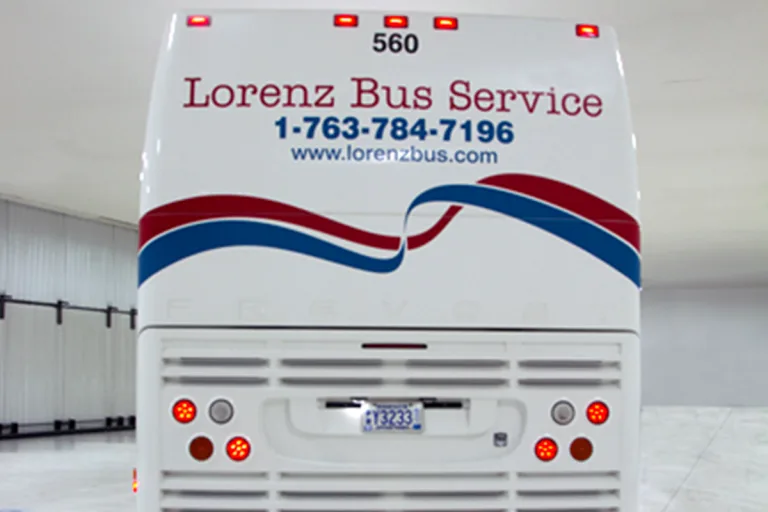 Rear of a Lorenz Bus Service coach displaying the company phone number 1-763-784-7196 and website www.lorenzbus.com