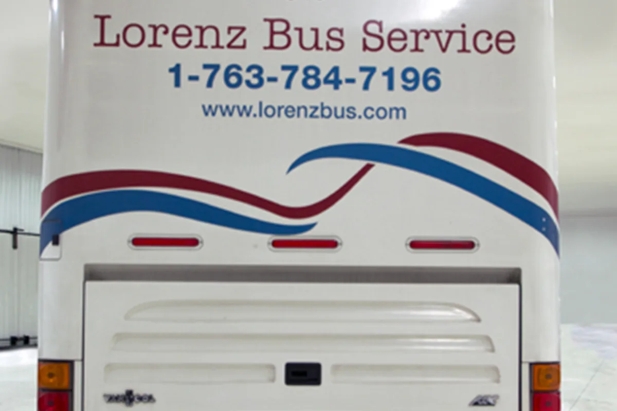 Rear of a Lorenz Bus Service coach displaying the company name, phone number 1-763-784-7196, and website www.lorenzbus.com