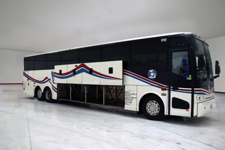 Lorenz Bus Service motorcoach with open undercarriage storage bays and red, white, and blue exterior graphics