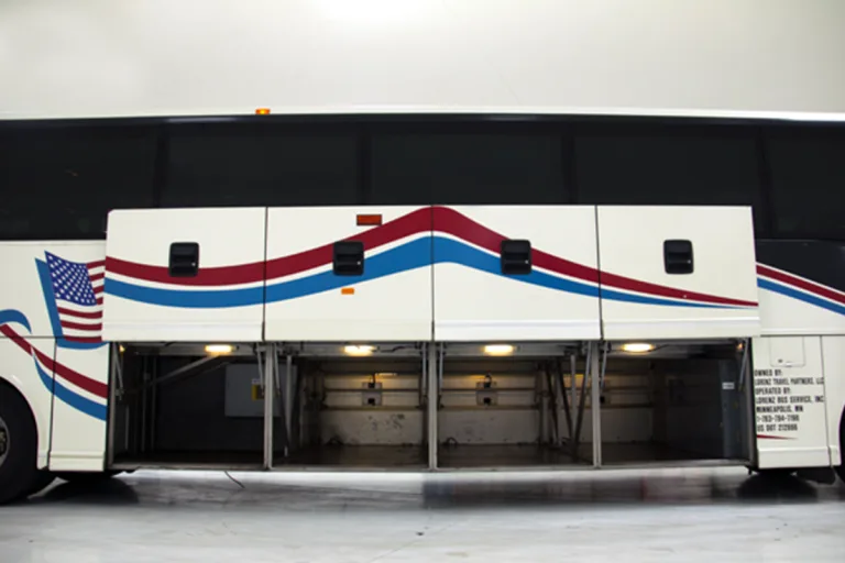 Open undercarriage storage bays on a Lorenz Bus Service motorcoach, showing spacious luggage compartments along the full length of the bus