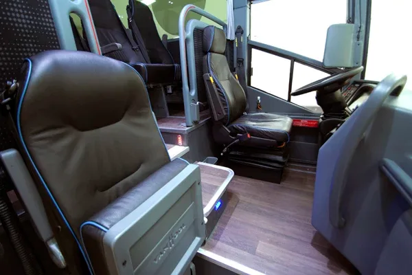 Charter motorcoach front cabin leather passenger seats with armrests and grab rail detail