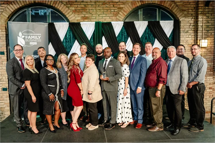Lorenz Bus Service team holding crystal trophy at the Twin Cities Business Family Business Awards ceremony