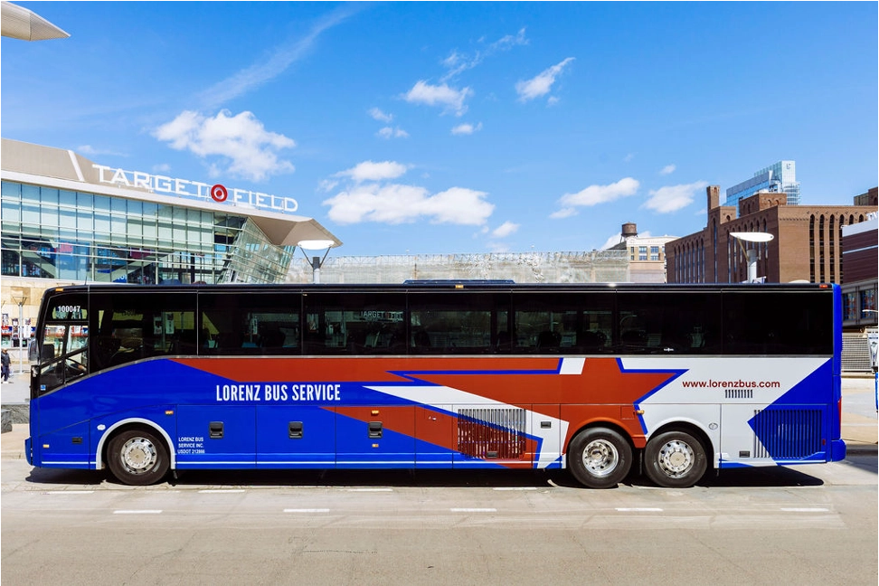 Blue Lorenz Bus Service motorcoach with red and white star graphics parked outside Target Field in Minneapolis