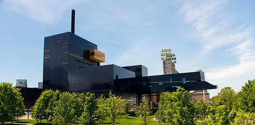 Guthrie Theater exterior in Minneapolis, with its distinctive dark building and cantilevered overhang against a blue sky
