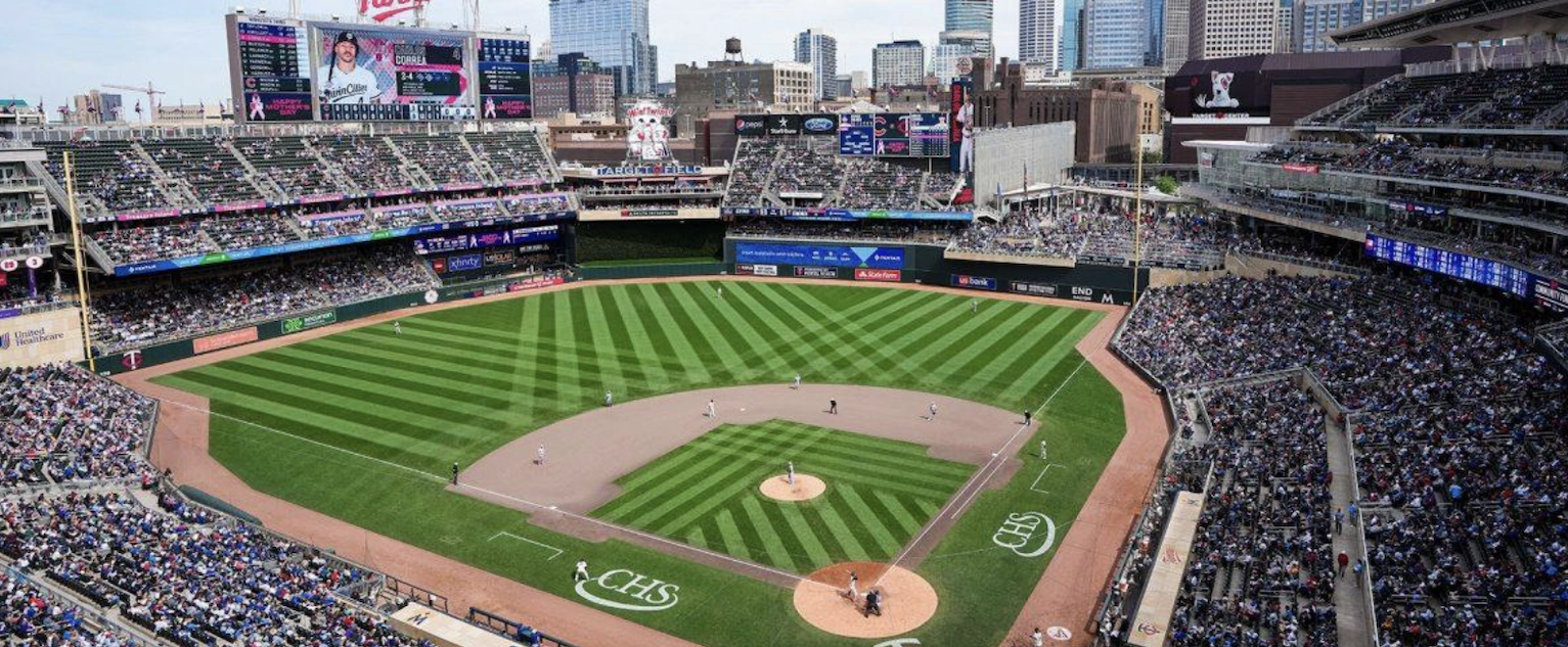Aerial view of a packed Target Field during a Minnesota Twins baseball game with the Minneapolis skyline in the background