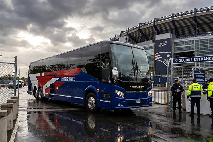 Lorenz Bus Service Prevost coach entering a secure stadium entrance on game day