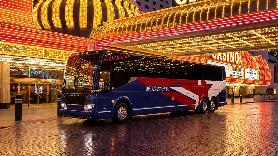 Lorenz Bus Service Prevost motorcoach parked outside a brightly lit casino at night
