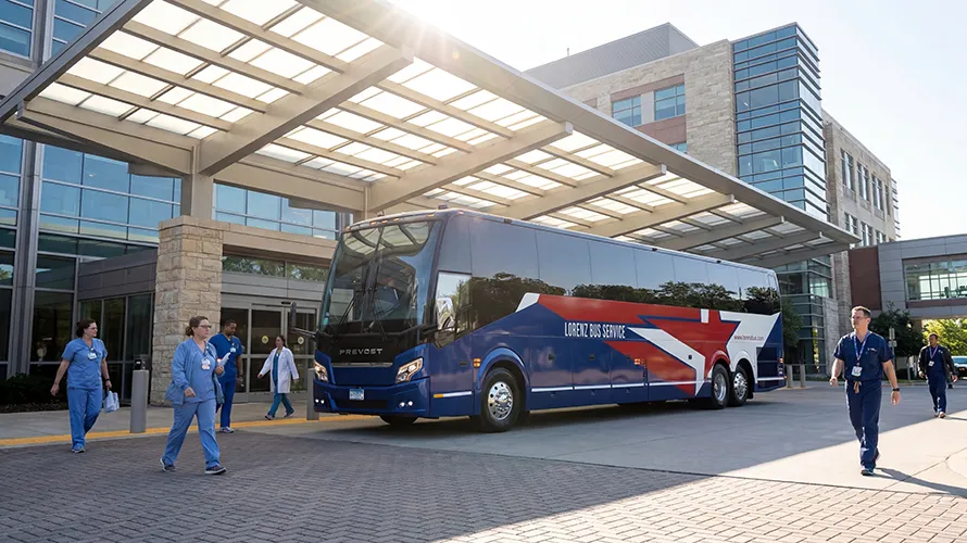 Lorenz Bus Service Prevost motorcoach parked under a hospital entrance canopy as medical staff walk nearby