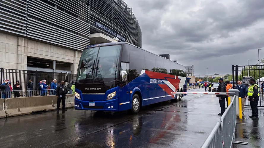 Lorenz Bus Service Prevost motorcoach entering a secured gate at a professional stadium on game day
