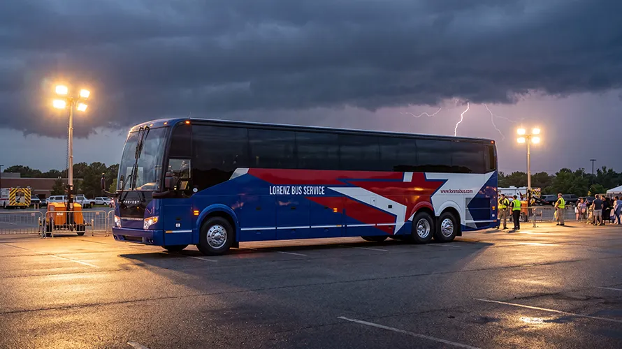 Lorenz Bus Service Prevost charter bus parked in a lot under stormy skies with lightning visible in the background