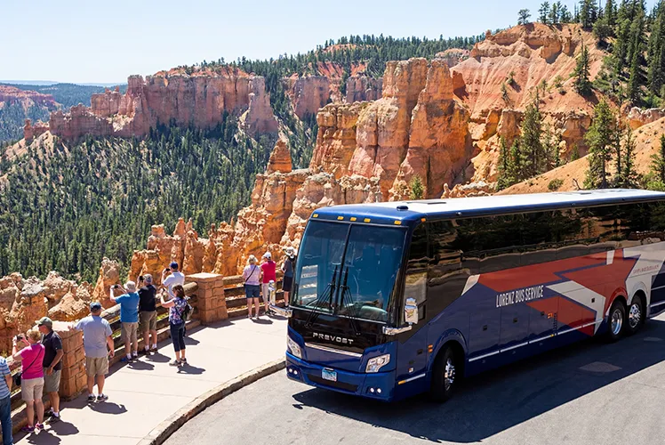 Lorenz Bus Service Prevost motorcoach parked at a scenic canyon overlook with passengers taking in the views