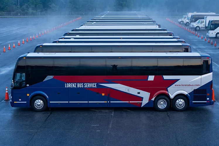 A fleet of Lorenz Bus Service motorcoaches lined up in formation, showcasing the company's large, well-maintained fleet capacity