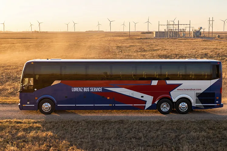 Lorenz Bus Service full-size motorcoach parked near a wind energy facility on an open Midwest plain