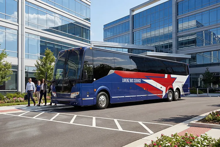 Lorenz Bus Service Prevost motorcoach parked outside a corporate office complex with passengers boarding