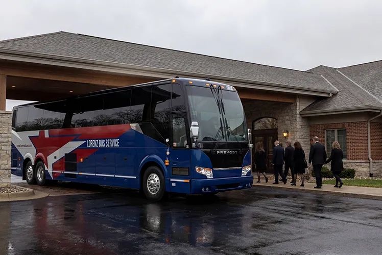 Lorenz Bus Service motorcoach parked at a venue entrance as formally dressed passengers board