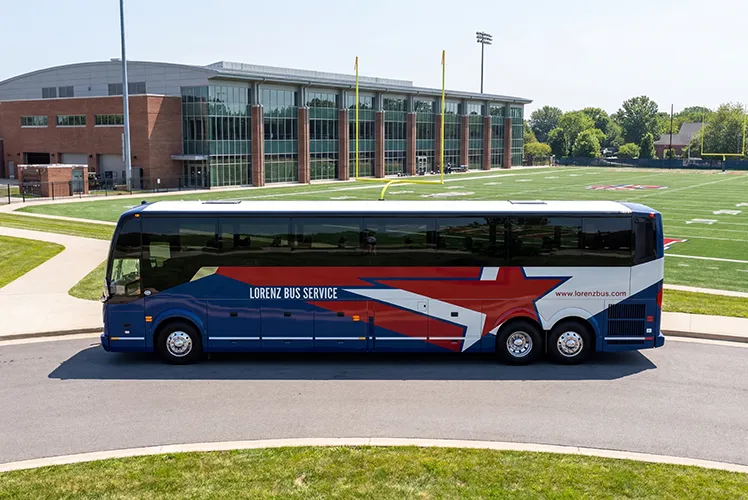 Lorenz Bus Service charter coach parked outside a college football stadium and athletic facility