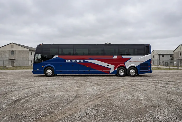 Lorenz Bus Service full-size motorcoach with red, white, and blue star graphic wrap parked on an open lot
