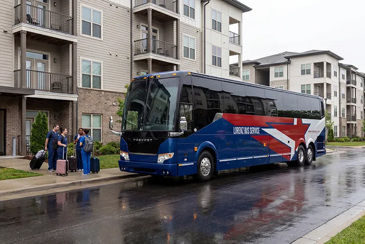 Lorenz Bus Service Prevost charter coach picking up passengers with luggage outside a residential apartment complex
