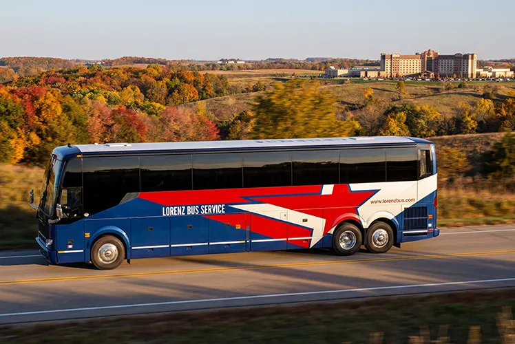 Lorenz Bus Service motorcoach traveling a highway through fall foliage in the Midwest