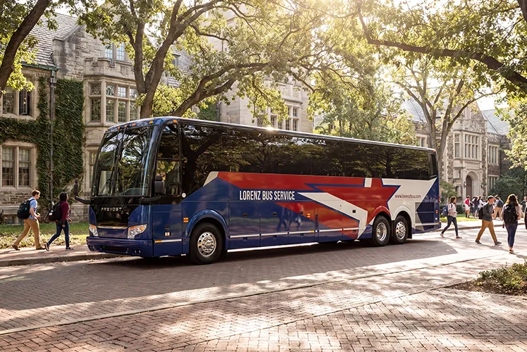 Lorenz Bus Service Prevost motorcoach parked on a university campus with students walking nearby