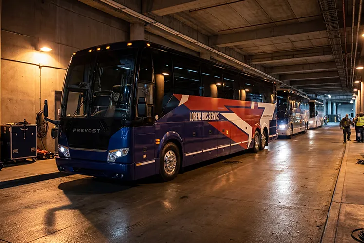 Lorenz Bus Service Prevost coaches staged in an indoor loading area, with staff visible alongside the fleet