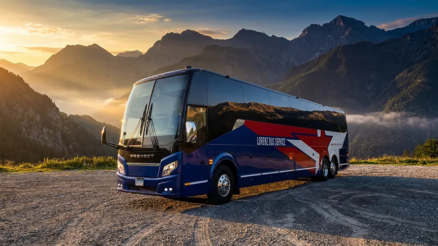 Lorenz Bus Service Prevost motorcoach parked at sunrise with mountain backdrop