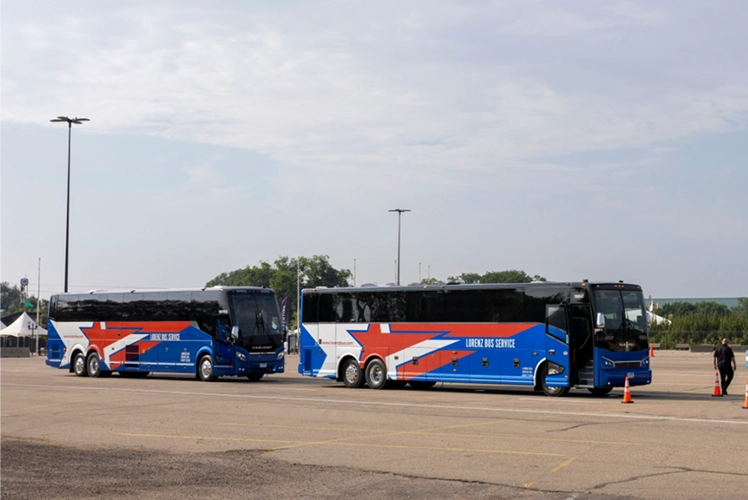 Two Lorenz Bus Service coaches staged side by side in an open lot, displaying the company's blue, red, and white star livery
