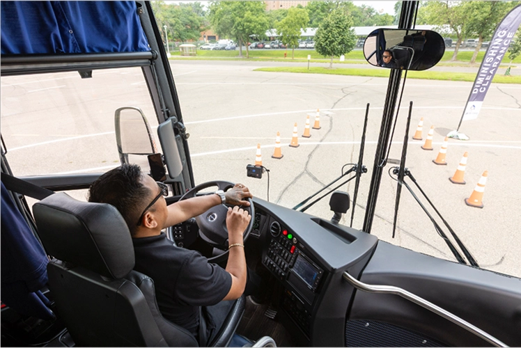 Bus driver navigating a cone course during a professional driving skills training exercise